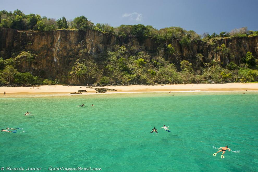 Imagem de turistas nadando com snorkel em Fernando de Noronha.